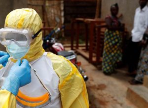 Profissionais da saúde ajustam equipamentos antes de entrar em local com suspeita de ebola na Re...